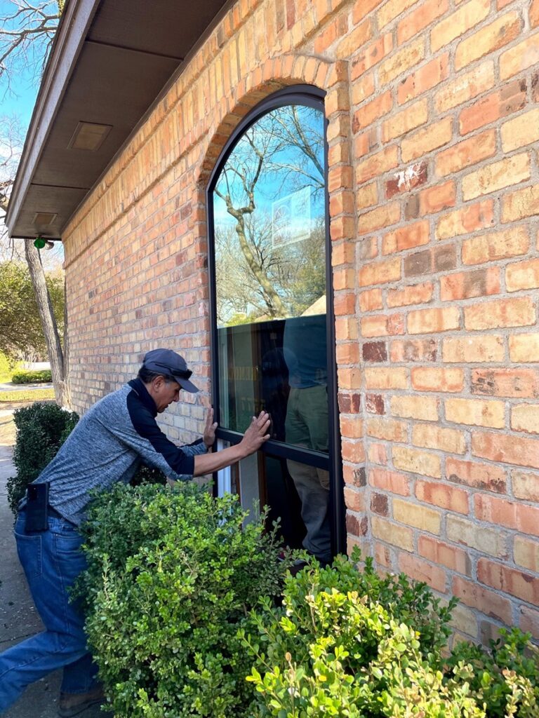 A man installing energy efficient replacement windows in Houston, TX.